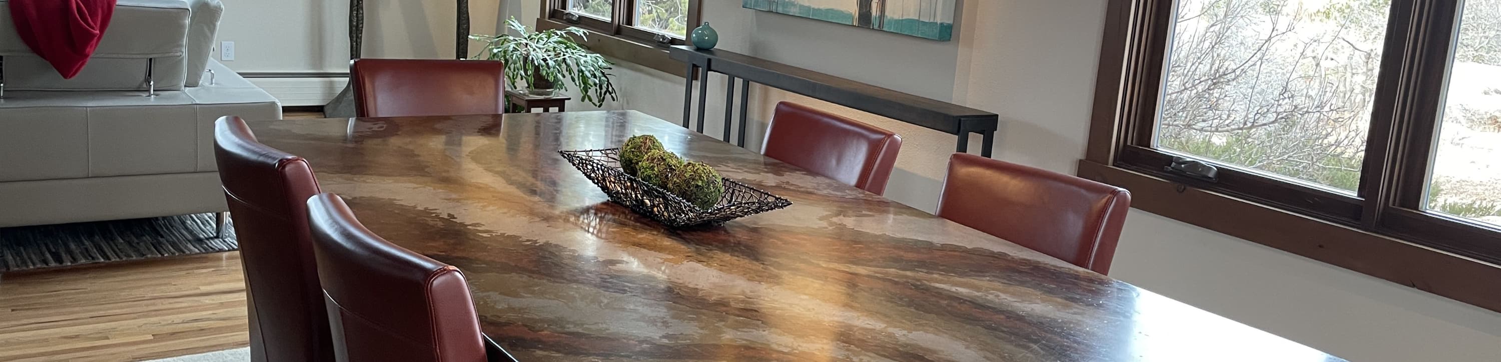 Concrete dining table with a flowing copper stain