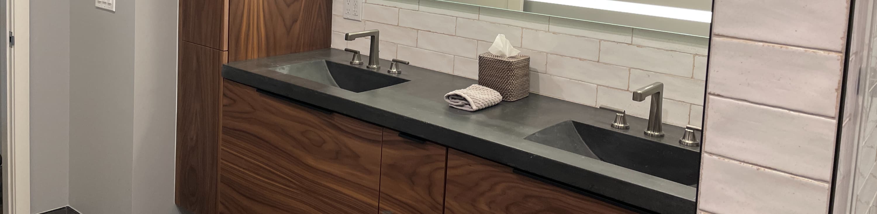 Charcoal concrete double vanity on walnut cabinets