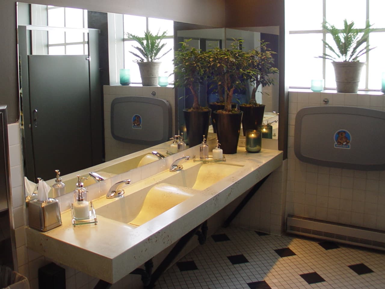 Cream concrete trough sink with a wave basin in a restroom