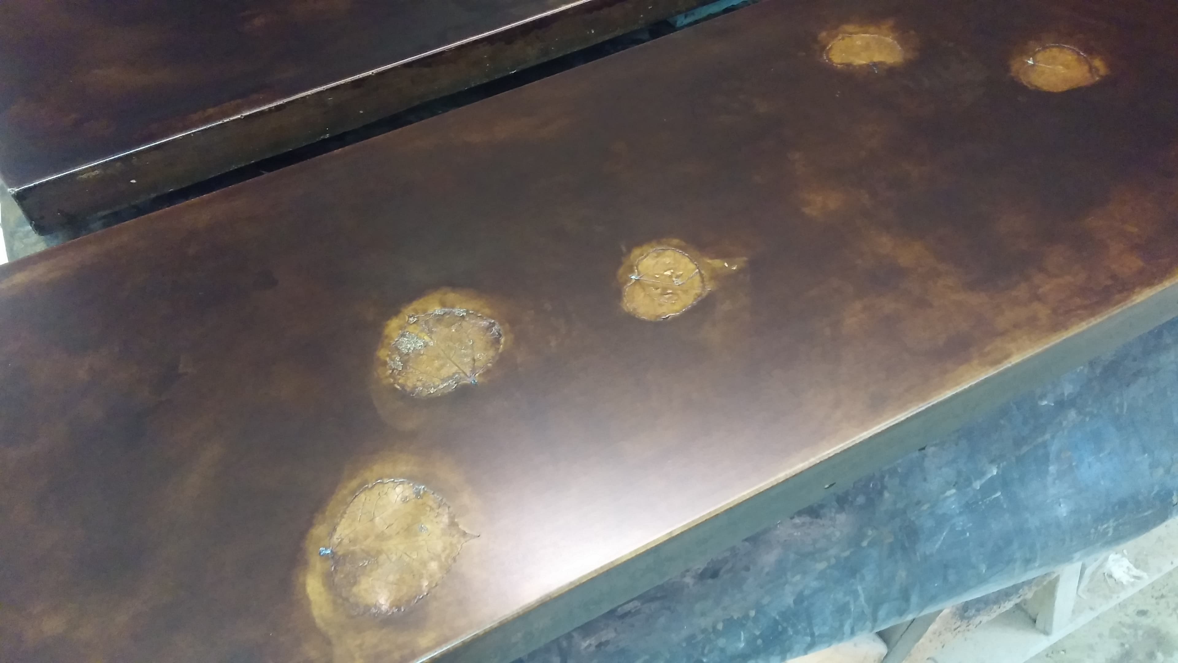 Dark copper-brown concrete with pressed leaf imprints